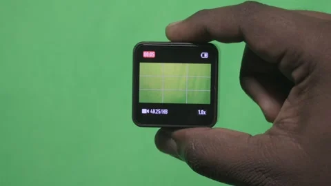 Hand Holding a Small Square Device Against a Green Screen. Stock Footage 342277905