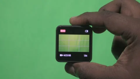 Hand Holding a Small Square Device Against a Green Screen. Stock Footage 342289655