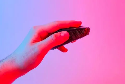 Hand holding a small wireless computer mouse with colorful background Stock Photos