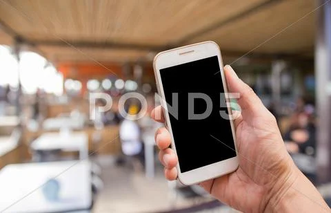 Hand holding smart phone with blurred background Stock Photos