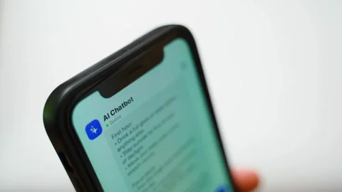 Hand holding smartphone with AI chatbot conversation on screen close-up Stock Footage 341405936