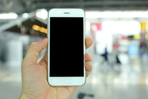 Hand holding smartphone with airport background Stock Photos