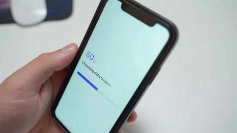 Hand holding smartphone with app checking data breach and showing password found Stock Footage 342810893