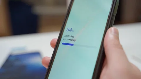 Hand holding smartphone with app restoring from backup and showing restore 스톡 동영상 342910488