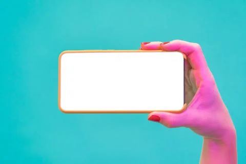 Hand holding a smartphone with blank screen on blue colour background free space Stock Photos