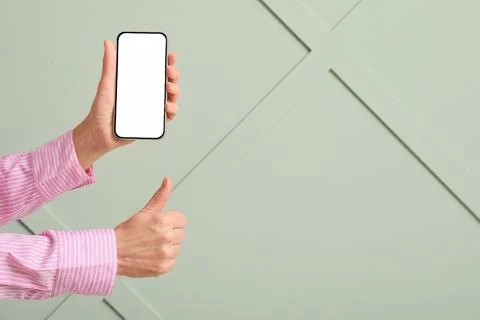 Hand holding smartphone with blank screen and thumbs up gesture for mobile ap Stock Photos