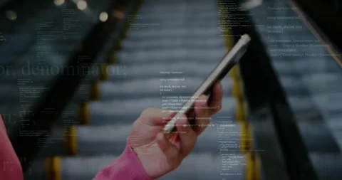 Hand holding smartphone capturing escalator, displaying C++ code overlay for Stock Footage 330169422