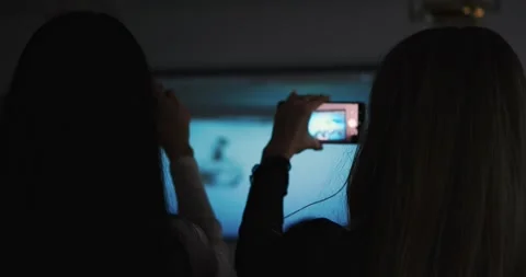 Hand holding smartphone capturing projection on screen during lecture Stock Footage 296332350