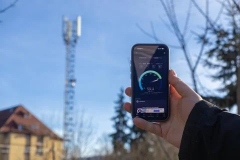 A hand holding a smartphone checking 5G mobile internet speed with a radio Foto stock