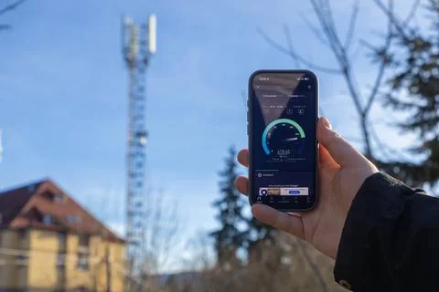 A hand holding a smartphone checking high speed mobile internet performance Foto stock