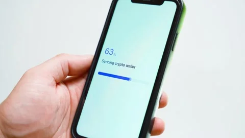 Hand holding smartphone with crypto wallet syncing stuck at 70 percent. Loading 스톡 동영상 342911295
