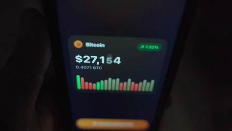 Hand holding smartphone with cryptocurrency trading app showing price chart in Stock Footage 340388529