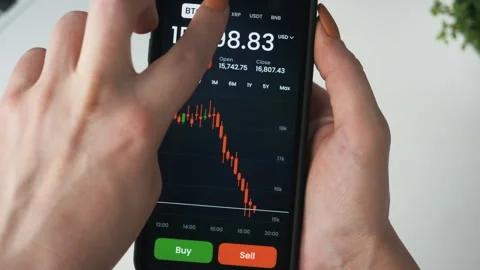 Hand holding smartphone displaying cryptocurrency market data Видео 328293200