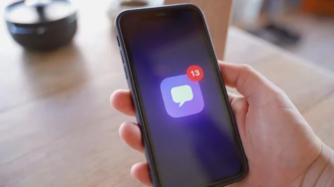 Hand holding smartphone displaying number of unread messages on screen 스톡 동영상 342602568