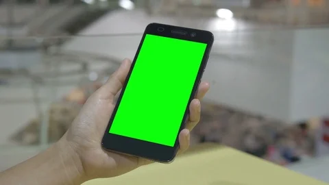 Hand holding smartphone green screen Stockbeeldmateriaal 76142984