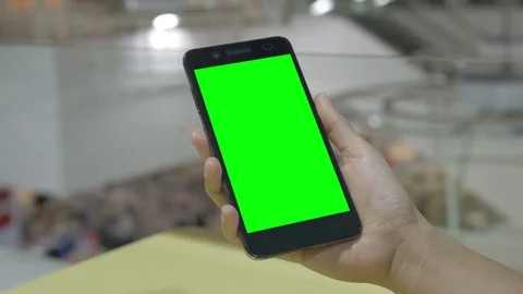 Hand holding smartphone green screen Stockbeeldmateriaal 76142985