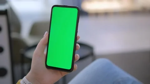 Hand holding smartphone with green screen, perfect for mockups or chroma key Stock Footage 277216106