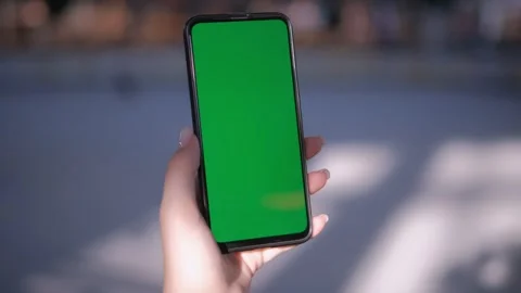 Hand holding smartphone with green screen, perfect for mockups or chroma key Video stock 277638410