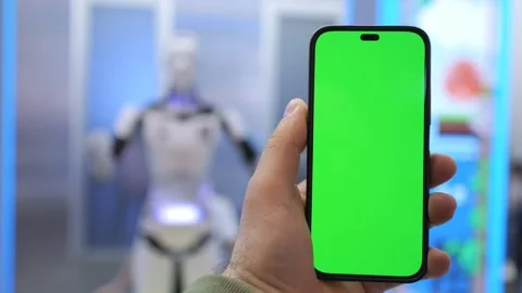 Hand Holding Smartphone with Green Screen in Front of Robot, futuristic Stock Footage 281425981