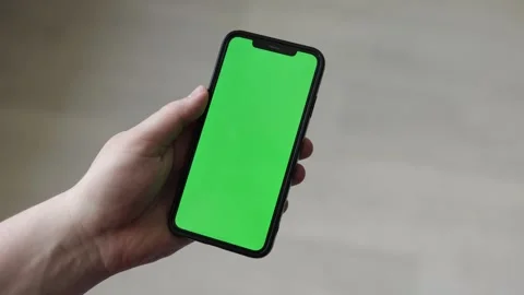 Hand holding a smartphone with a green screen for easy editing and customization Stock Footage 339215007
