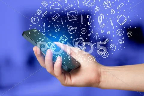Hand holding smartphone with hand drawn media icons and symbols Stock Photos