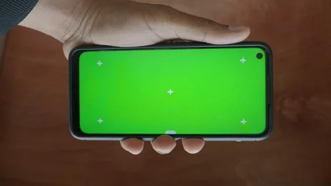 Hand holding smartphone horizontal with bright green screen chroma key. Stock-Footage 332886501