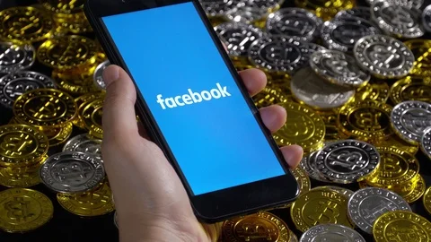 Hand holding Smartphone with Libra logo and Cryptocurrency digital golden coins Stock Footage 111743386