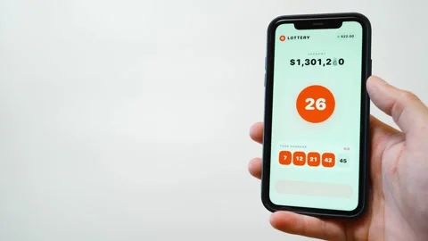 Hand holding smartphone with lottery app drawing numbers and showing jackpot win Stock-Footage 342811142