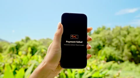 Hand Holding Smartphone with Payment Failed Message Displayed Against Bright Stock Footage 318474504