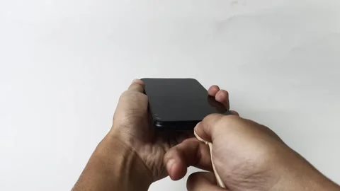 Hand holding smartphone plugging in charging cable Video stock 313381374