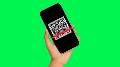 Hand holding a smartphone with a QR code reading on the screen, green background Video stock 152836963