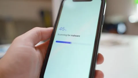 Hand holding smartphone with security app scanning for malware and showing no Stock Footage 342910897