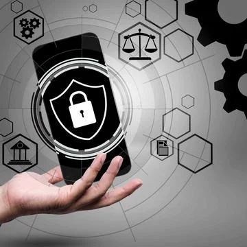 Hand holding a smartphone with a security shield icon, surrounded by legal,.. 库存照片
