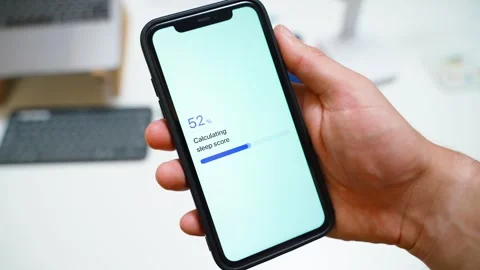 Hand holding smartphone with sleep app calculating sleep score and showing not Stock Footage 342910749
