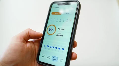 Hand holding smartphone with sleep tracking app showing sleep quality statistics Stock Footage 342129839