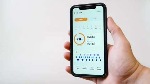 Hand holding smartphone with sleep tracking app showing sleep quality score and Vídeo Stock 342811119