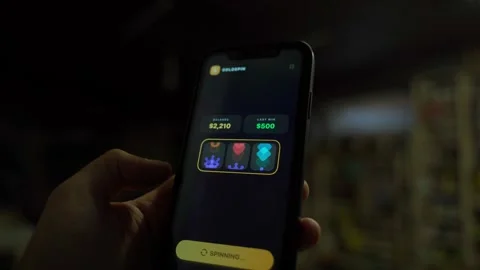 Hand holding smartphone with slot machine app showing jackpot win in the dark Stock-Footage 342129377