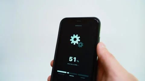 Hand holding smartphone with software update downloading on dark screen close-up Stock Footage 341078500