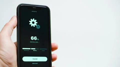 Hand holding smartphone with system update downloading progress on dark screen Stock Footage 342129466