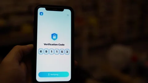 Hand holding smartphone with two factor authentication verification code on Stock Footage 340388616