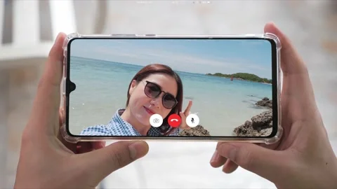 Hand holding smartphone while Happy Asian woman selfie video on the beach Stock-Footage 150473295