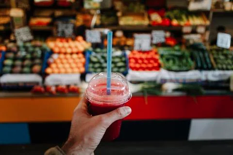 Hand holding a smoothie with red color. Stock Photos