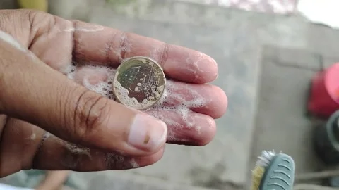 Hand holding soap bubble coin and toothbrush  cleaning money with toothbrus.. Stock Footage 331239823