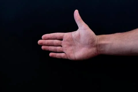Hand holding something on black background Stock Photos
