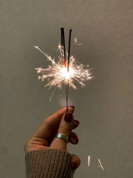 Hand holding sparklers on a simple background Stock Photos