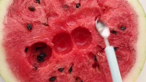 Hand holding spoon extracting watermelon flesh ASMR experience Stock Footage 314054450