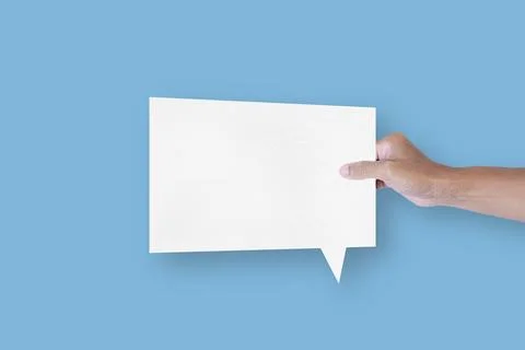 Hand holding a square shaped white paper bubble speech bubble isolated on l.. Stock Photos