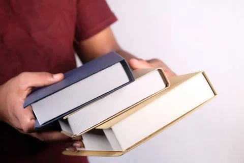 Hand holding stack of books on white background Stock Photos