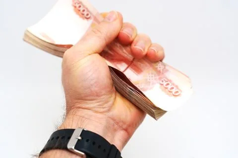 Hand holding a stack of cash tightly in a fist Stock Photos