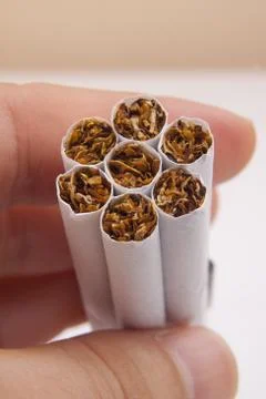Hand holding stack of Cigarettes Stock Photos